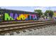 Street view of colorful 'Marietta' mural, railway tracks, and surrounding cityscape at 326 Roswell Se St # 508, Marietta, GA 30060