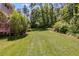 Expansive backyard featuring lush green grass, mature trees, and landscaped garden beds perfect for outdoor enjoyment at 9041 Par Dr, Douglasville, GA 30134