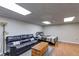 Spacious basement area featuring a black leather couch, wooden chest, and bed with neutral colored bedding at 9041 Par Dr, Douglasville, GA 30134