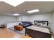 Open basement area with a bed, a black leather couch, a wooden chest, and a half wall with countertop at 9041 Par Dr, Douglasville, GA 30134