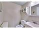Cozy bathroom with a toilet, white sink, mirrored cabinet, and small, round mirror above the toilet at 9041 Par Dr, Douglasville, GA 30134