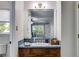 Bathroom vanity features a wood cabinet with blue-tile countertop and large mirror with decorative lighting at 9041 Par Dr, Douglasville, GA 30134