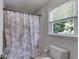 Bright bathroom features a shower with patterned curtain and a window that offers lots of natural light at 9041 Par Dr, Douglasville, GA 30134
