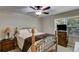 This bedroom features a ceiling fan, a window with wooded view, and an iron-frame bed with wood accents at 9041 Par Dr, Douglasville, GA 30134