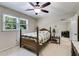 Comfortable bedroom with ceiling fan and light; window has view of trees; classic wooden bedframe at 9041 Par Dr, Douglasville, GA 30134