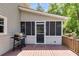 Cozy deck off the house with grill, exterior door to the sunroom, and wooden railing overlooking the backyard at 9041 Par Dr, Douglasville, GA 30134