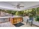 Relaxing sunroom with a hot tub, ceiling fan, wood flooring, and screened windows overlooking a wooded area at 9041 Par Dr, Douglasville, GA 30134