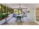 Large screened in porch features a table and chairs, ceiling fan, wood floors, and screened windows at 9041 Par Dr, Douglasville, GA 30134