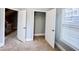 Bedroom with an open closet, window, and two white doors in a neutral color palette at 625 Chestnut St # D, Atlanta, GA 30354