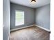 Cozy bedroom featuring a large window, neutral paint, and carpet flooring at 625 Chestnut St # D, Atlanta, GA 30354