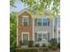 Charming two-story townhome featuring a mix of brick and siding, complemented by gray shutters and well-manicured landscaping at 9155 Nesbit Ferry Rd # 65, Alpharetta, GA 30022