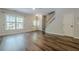 Spacious living room with hardwood floors, large window, ceiling fan and staircase at 9155 Nesbit Ferry Rd # 65, Alpharetta, GA 30022