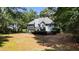 View of the home's backyard, featuring a well-maintained lawn and tree coverage at 7635 Wynfield Dr, Cumming, GA 30040
