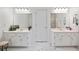 Bright bathroom features double vanities, white cabinets, marble floors, and modern lighting fixtures at 7635 Wynfield Dr, Cumming, GA 30040