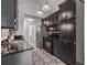 Well-lit kitchen features black cabinets, granite countertops, stainless steel appliances, and a decorative tile backsplash at 7635 Wynfield Dr, Cumming, GA 30040