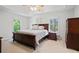 Spacious main bedroom with a tray ceiling, large windows, a king bed, and dark wood furnishings at 7635 Wynfield Dr, Cumming, GA 30040