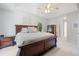 Bright main bedroom boasts a tray ceiling, a king-size bed, large windows, and dark wood furnishings at 7635 Wynfield Dr, Cumming, GA 30040