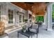 Inviting covered patio with wood ceiling, outdoor seating, fireplace, and access to lush backyard at 790 Lakeview Ne Ave, Atlanta, GA 30308