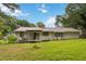 A view of the backyard and the back of the home with a covered porch and a green, grassy lawn at 1353 Litchfield Ct, Snellville, GA 30078