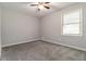 Neutral bedroom features a ceiling fan, plush carpet, fresh paint, and a large window at 1353 Litchfield Ct, Snellville, GA 30078