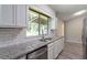 Bright kitchen with stainless steel appliances, granite countertops, white cabinets, and tile backsplash at 1353 Litchfield Ct, Snellville, GA 30078