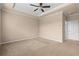 Spacious bedroom with tan carpeting, ceiling fan and light walls with white trim at 1973 Cobblestone Cir, Brookhaven, GA 30319