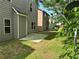 Grassy backyard with a concrete patio and neighboring homes with siding at 678 Sweet Ashley Way, Loganville, GA 30052