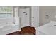 Bathroom featuring a tub, walk in shower, and wood-style floors at 1280 Chandler Ridge Dr, Lawrenceville, GA 30045