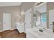Bright bathroom with double vanity, large mirror, and wood-look floors at 1280 Chandler Ridge Dr, Lawrenceville, GA 30045
