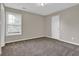 Cozy bedroom with neutral carpet, a window, and a door to the hallway at 1280 Chandler Ridge Dr, Lawrenceville, GA 30045