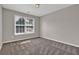 Cozy bedroom showcasing neutral walls, plush carpet, and a sunlit window at 1280 Chandler Ridge Dr, Lawrenceville, GA 30045