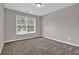 Cozy bedroom showcasing neutral walls, plush carpet, and a sunlit window at 1280 Chandler Ridge Dr, Lawrenceville, GA 30045