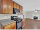 Modern kitchen featuring wood cabinets, black appliances, and an opening to the living room at 1280 Chandler Ridge Dr, Lawrenceville, GA 30045