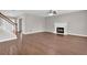 Spacious living room featuring hardwood floors, a fireplace, and an adjacent staircase at 1280 Chandler Ridge Dr, Lawrenceville, GA 30045