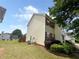 Side of a tan house with red shutters, green bushes, and small fenced in area at 130 Hazelhurst Dr, Covington, GA 30016