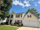 Two-story house with two-car garage, red shutters, well-kept lawn, and a neatly paved driveway at 130 Hazelhurst Dr, Covington, GA 30016