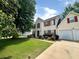 Two-story home with attached two-car garage, lush green lawn, and mature landscaping at 130 Hazelhurst Dr, Covington, GA 30016