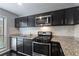 Well-lit kitchen with stainless steel appliances, granite countertops, and dark cabinetry at 2510 Cumberland Se Ct, Smyrna, GA 30080