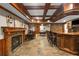 Spacious basement area with stone fireplace, pool table, bar with seating and coffered ceilings at 4840 Spring Park Cir, Suwanee, GA 30024