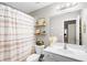 Bright bathroom features a single sink vanity, toilet, and shower with patterned curtain at 4840 Spring Park Cir, Suwanee, GA 30024