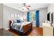 Bedroom features a cozy bed, hardwood floors, and window with blue curtains at 4840 Spring Park Cir, Suwanee, GA 30024