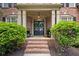 Inviting entryway with double doors, classic brick steps, and manicured greenery creating a warm welcome at 4840 Spring Park Cir, Suwanee, GA 30024