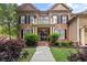 Charming brick home featuring a covered entrance, lush landscaping, and a manicured lawn with an inviting walkway at 4840 Spring Park Cir, Suwanee, GA 30024