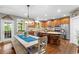 Eat-in kitchen with stainless steel appliances, wood cabinetry, and a farmhouse-style dining table at 4840 Spring Park Cir, Suwanee, GA 30024