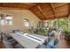 Inviting screened-in patio featuring wood ceiling, wicker furniture, and large outdoor dining area at 4840 Spring Park Cir, Suwanee, GA 30024