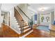 Elegant staircase with wood and iron details, leading to the upper level, with views of the foyer and entryway at 4840 Spring Park Cir, Suwanee, GA 30024