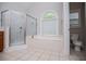 Bathroom featuring a separate shower, large tub under a window, and white tile floor at 5995 Azalea Ridge Dr, Douglasville, GA 30135