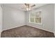 Cozy bedroom featuring plush carpeting, a modern ceiling fan, and ample natural light at 7165 Jonsway, Cumming, GA 30041