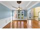 Elegant dining room featuring hardwood floors, wainscoting, a chandelier, and bright natural light at , Suwanee, GA 30024