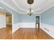 Elegant dining room featuring hardwood floors, wainscoting, a chandelier, and bright wall color at , Suwanee, GA 30024